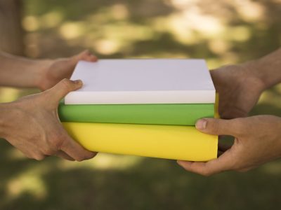 crop-students-passing-pile-textbooks-park